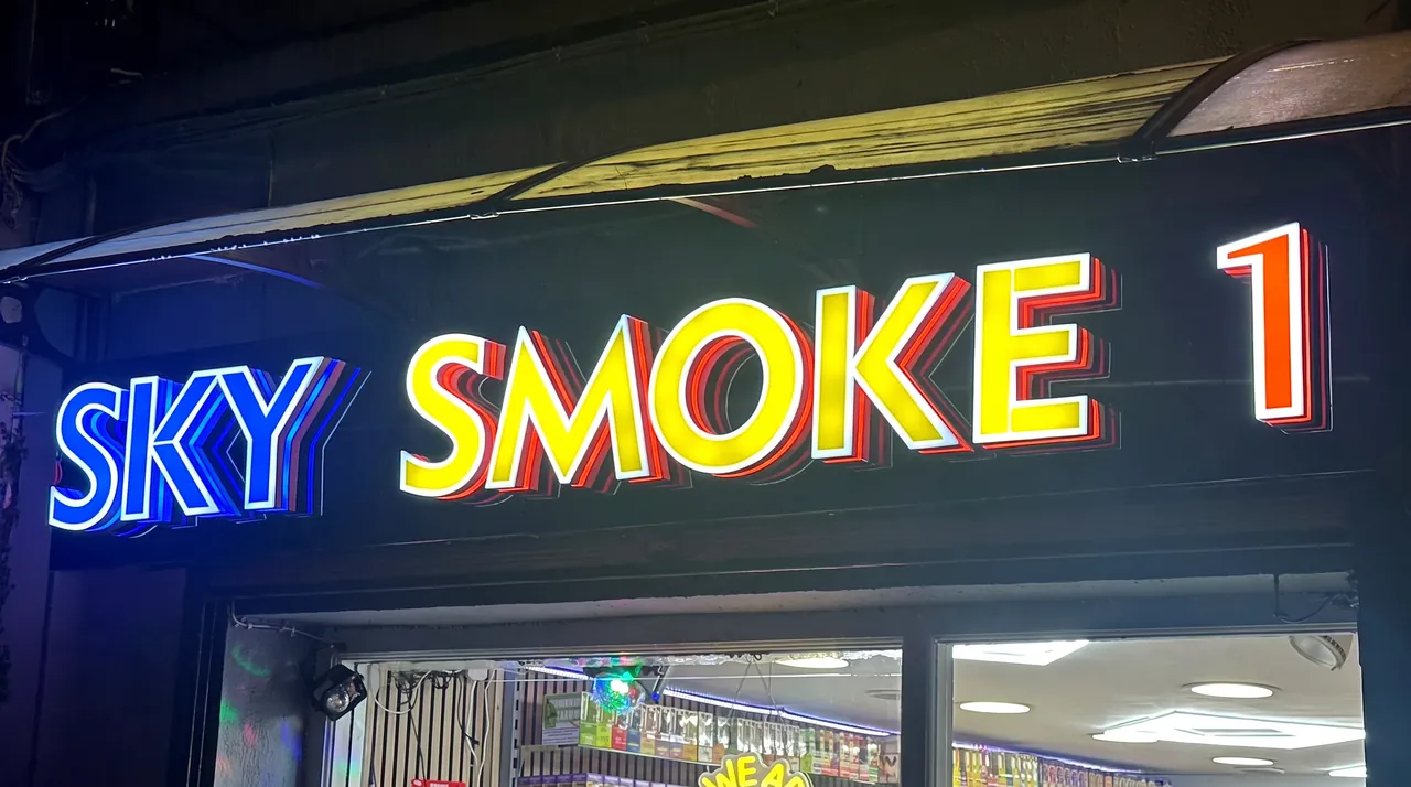 Sky Smoke 1 shopfront in Cork at night: blue, yellow and orange illuminated 3D letters with layered returns.