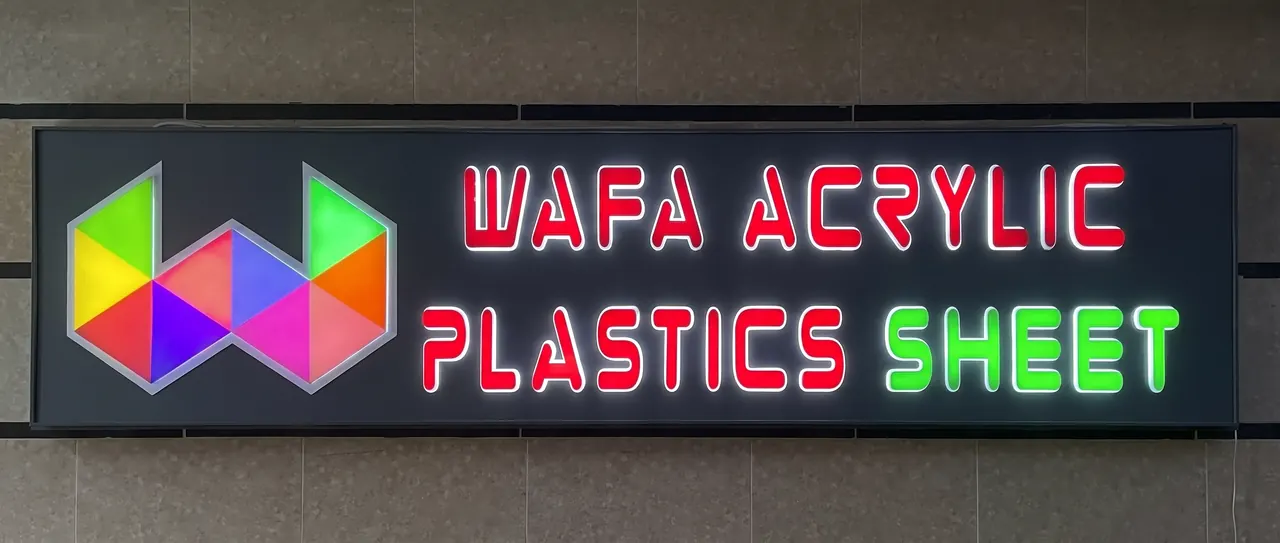 Illuminated fascia reading WAFA ACRYLIC PLASTICS SHEET in red and green LED-lit letters beside a multicoloured logo.